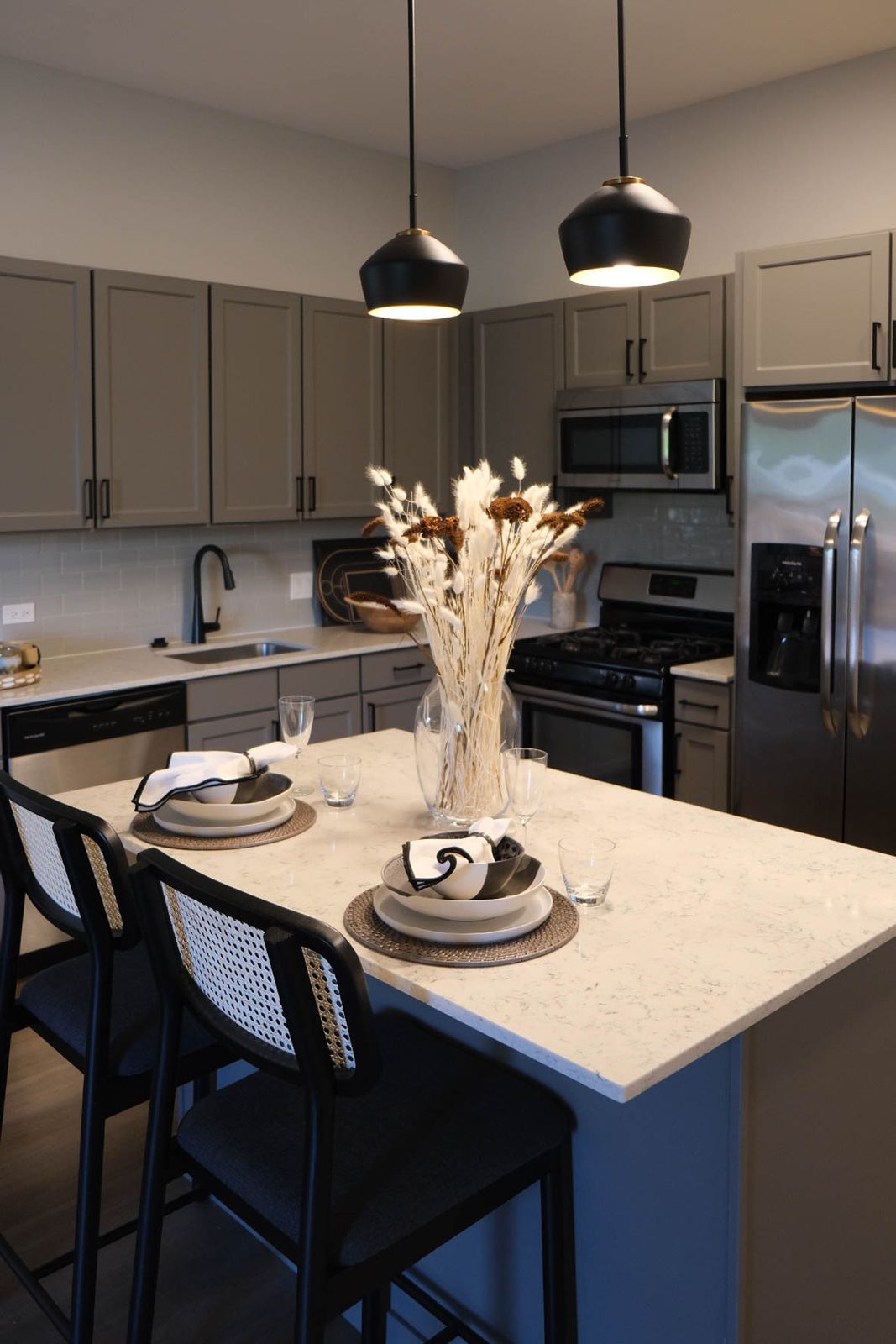 A kitchen with a large island and a vase of flowers on it.