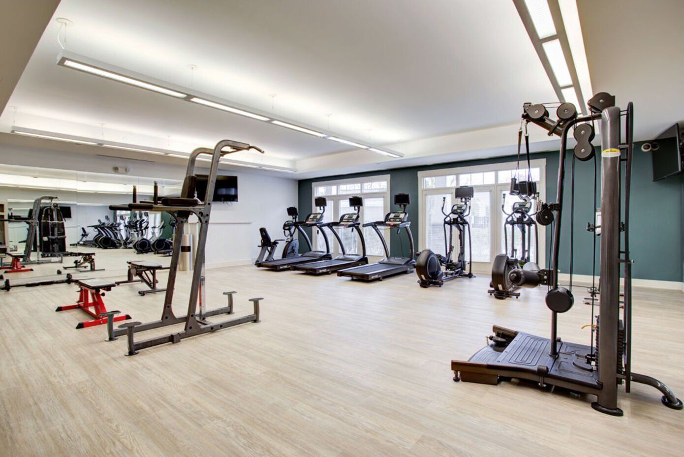 A large gym filled with lots of exercise equipment.