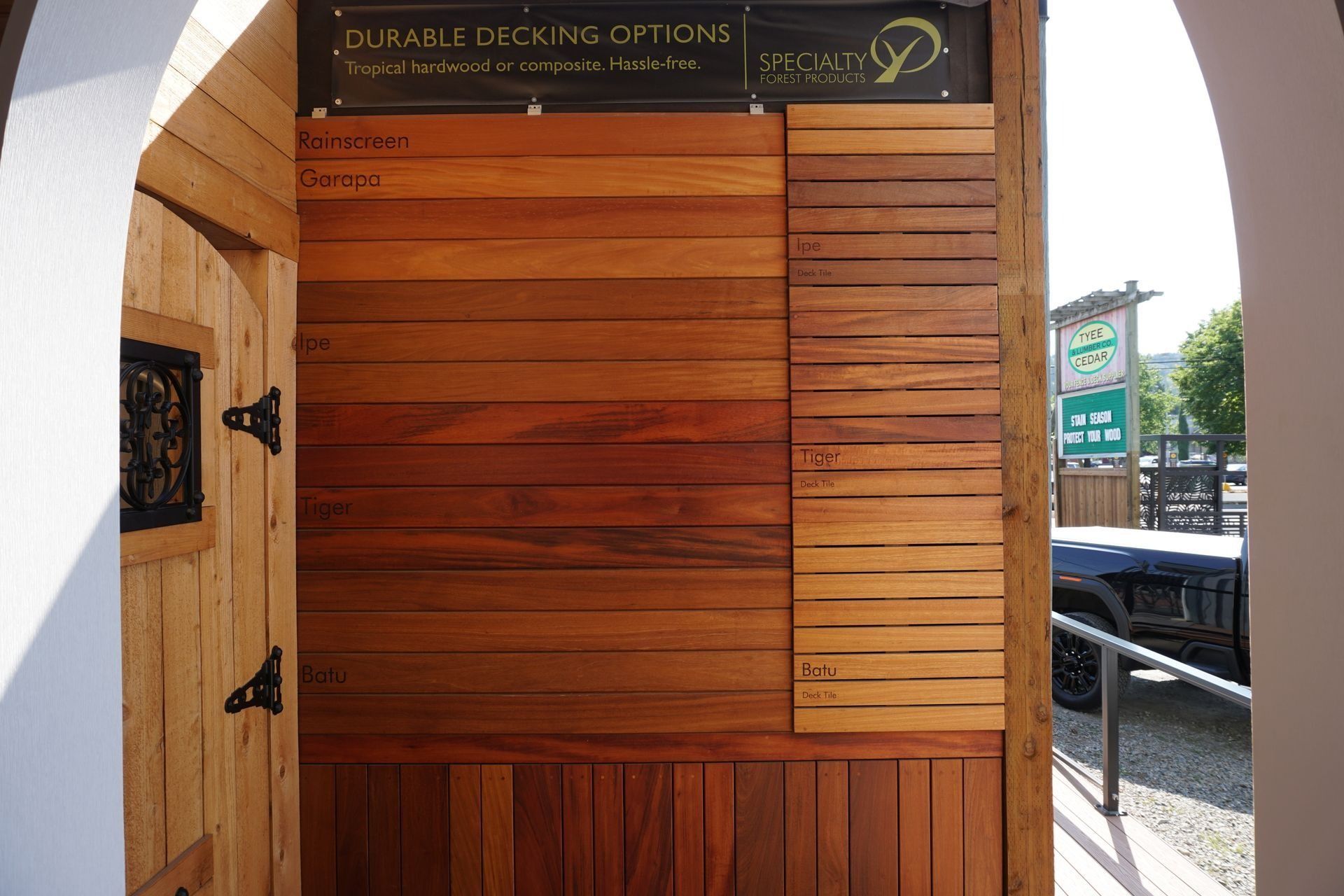 Wooden decking options display on a wall. Sample boards show various wood types and finishes.