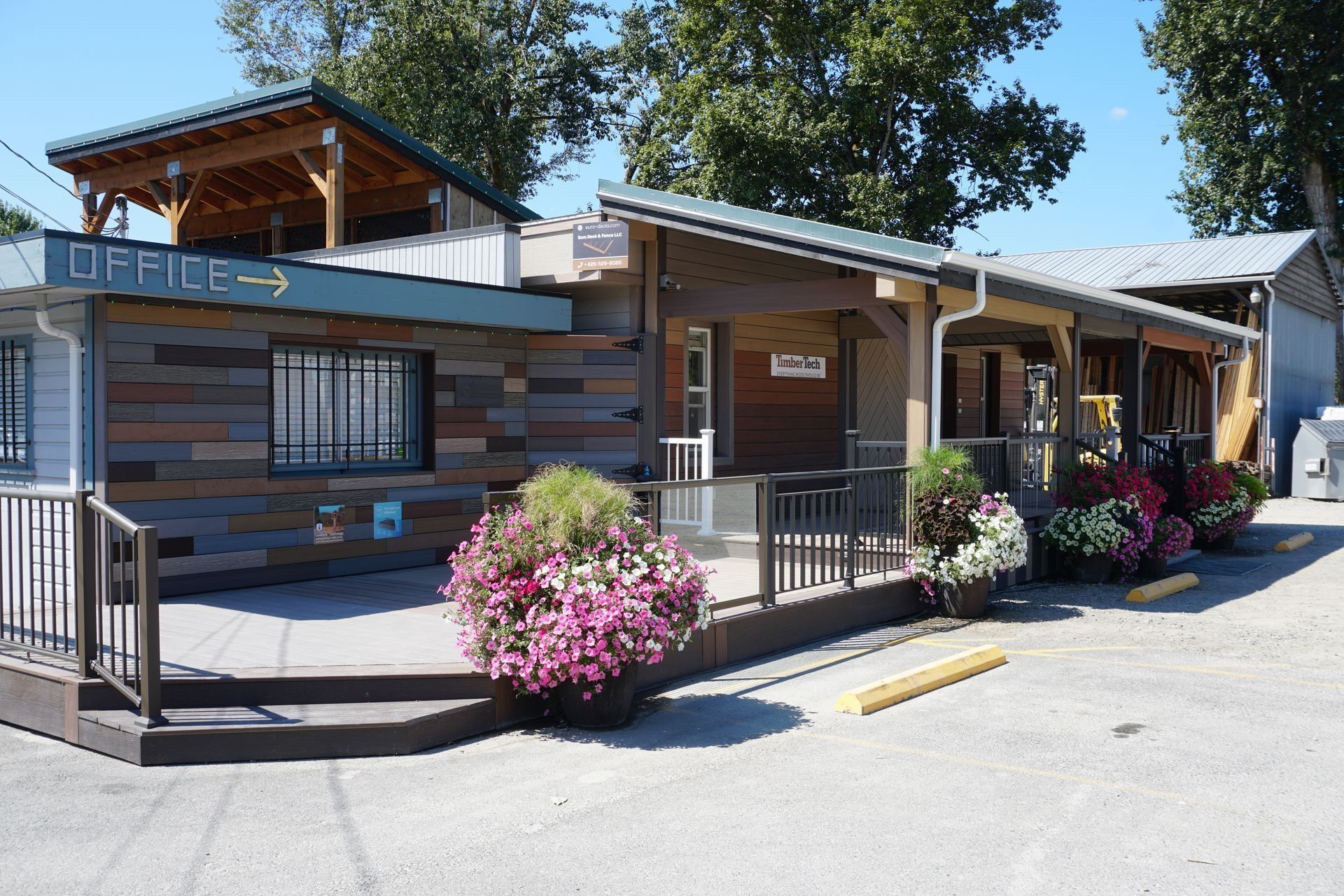 Office building with wooden siding, deck, and flower baskets.
