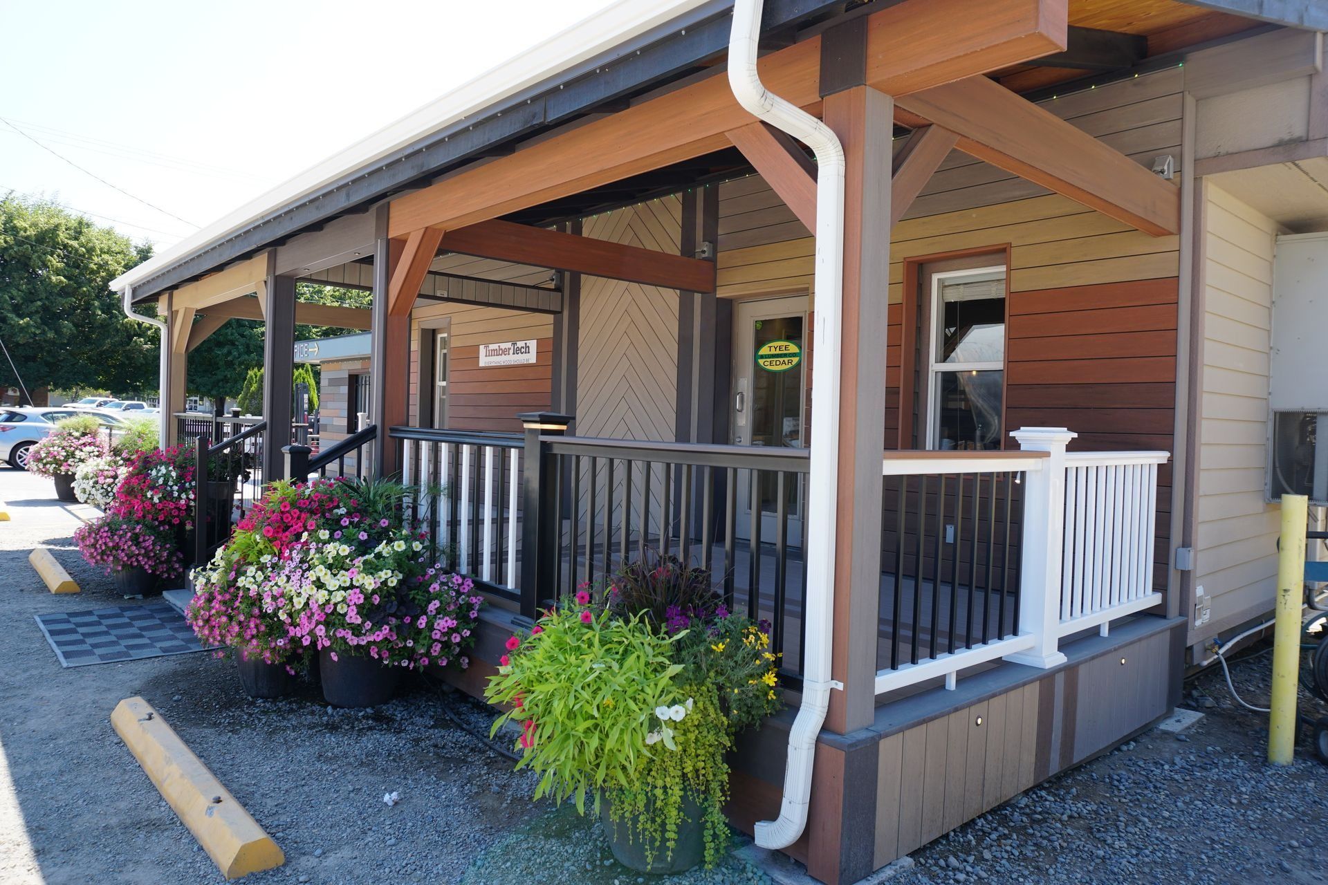 Building with a covered porch decorated with hanging flowers.