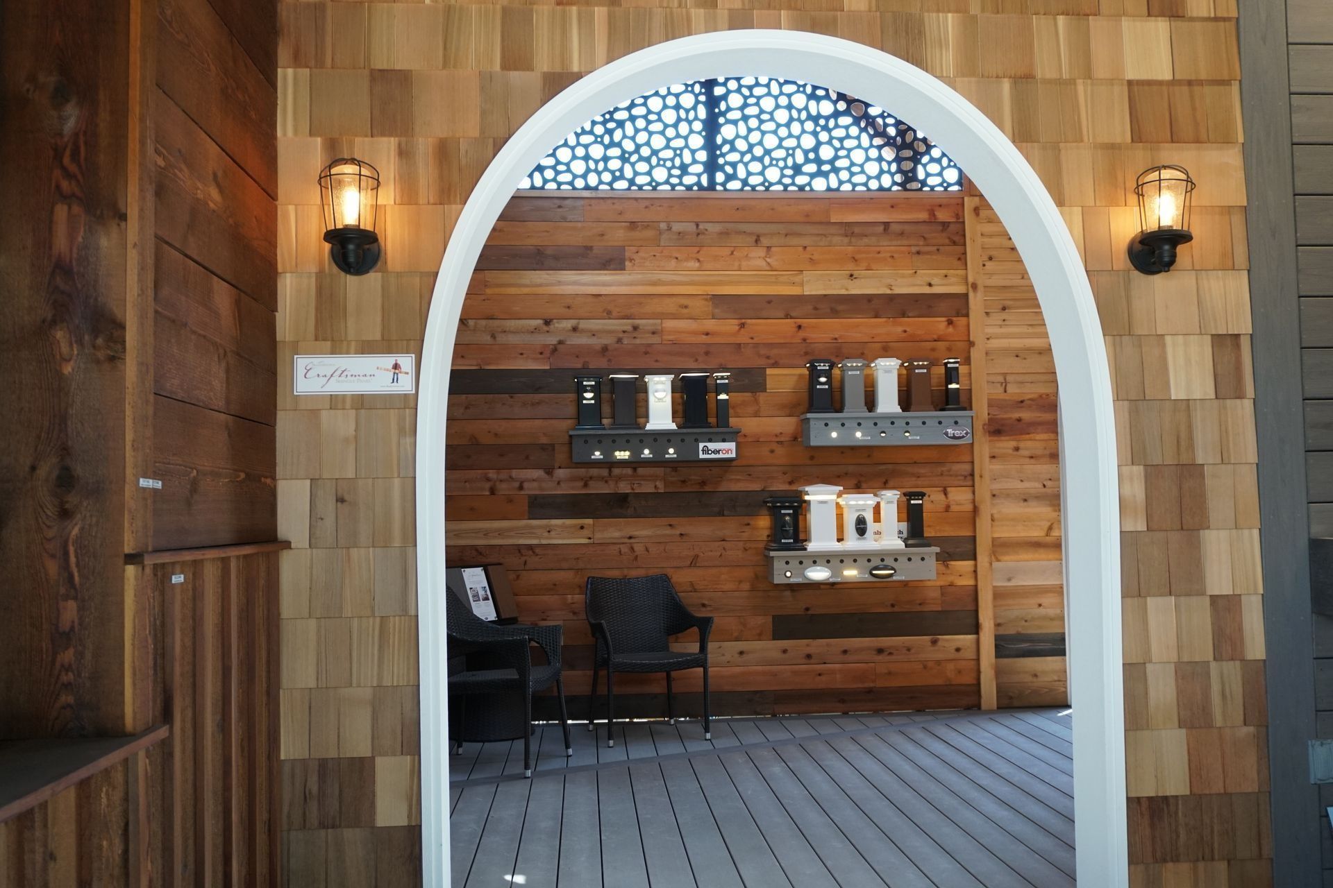Archway entrance to a room with wood paneling and products on display shelves. Two sconce lights.