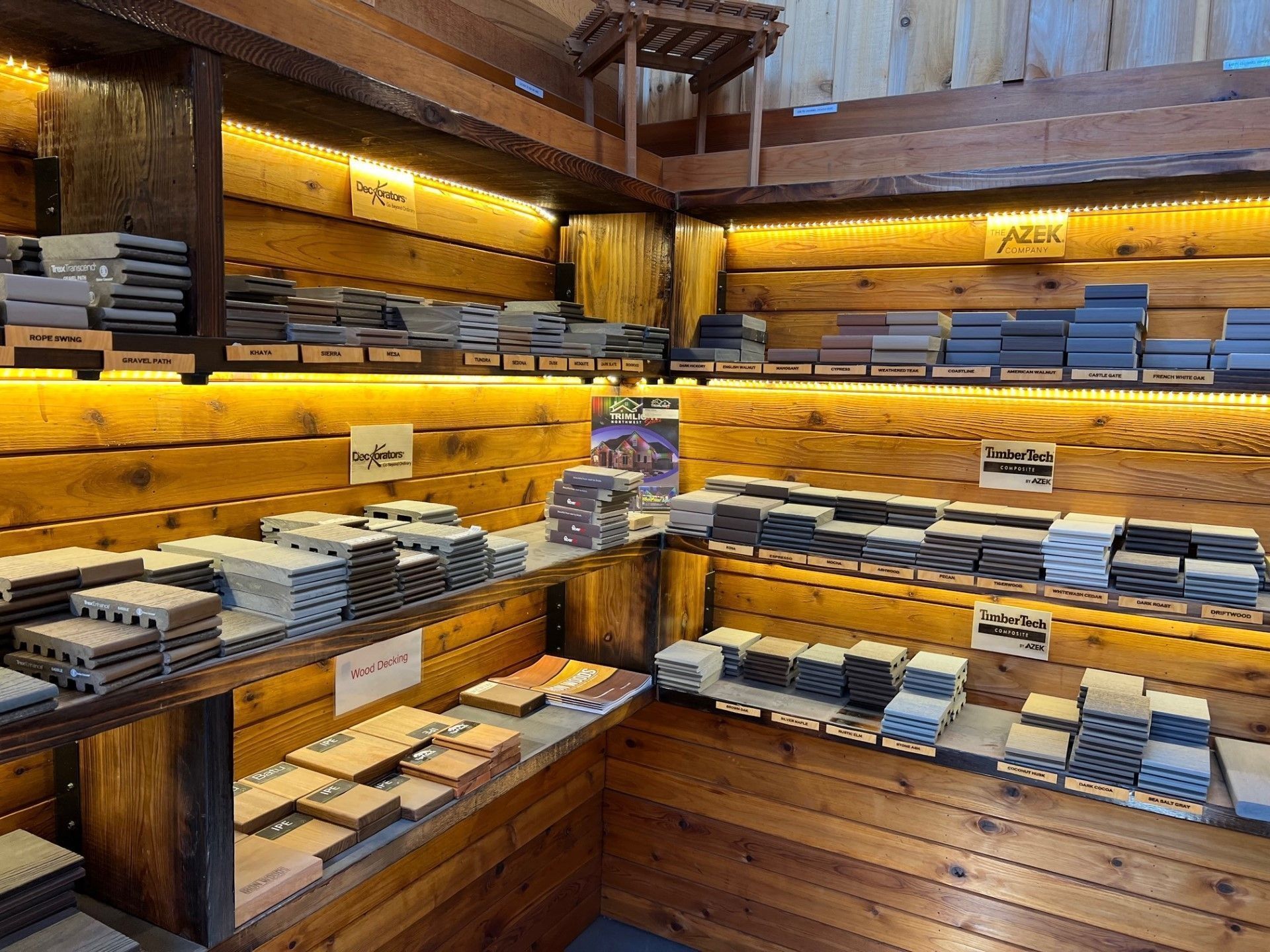 Wood-paneled room displays various stone tiles on wooden shelves, illuminated by overhead lighting.