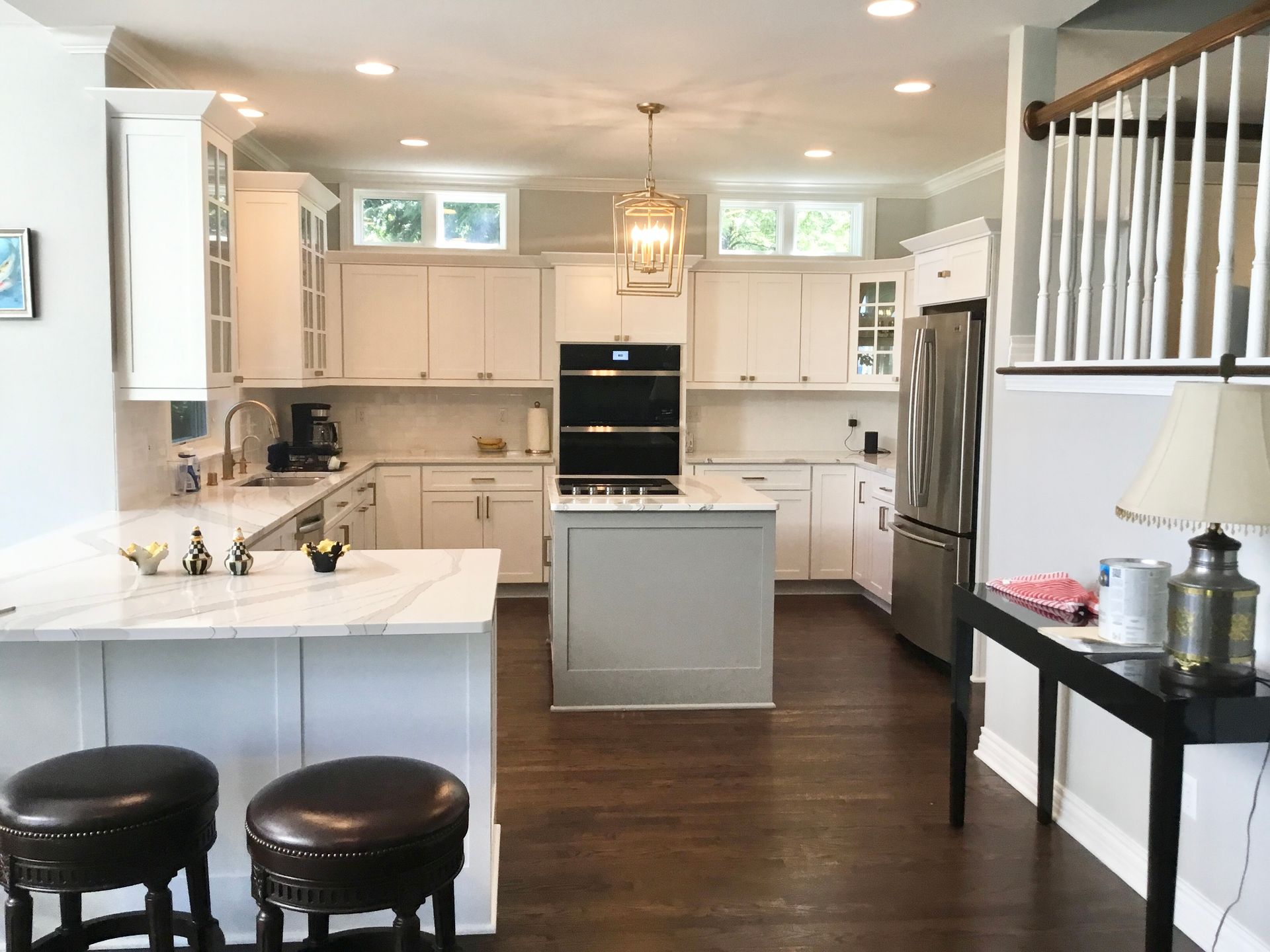 U-shaped kitchen with wood cabinets, black countertops, and a window with shutters over the sink.