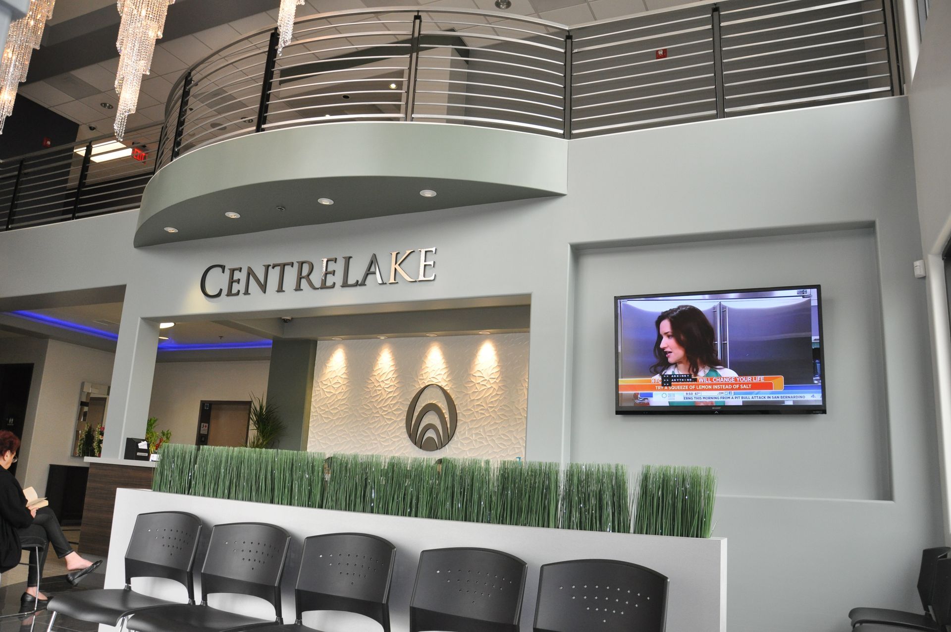 Interior view of CentreLake reception area: waiting chairs, TV, logo, and balcony.