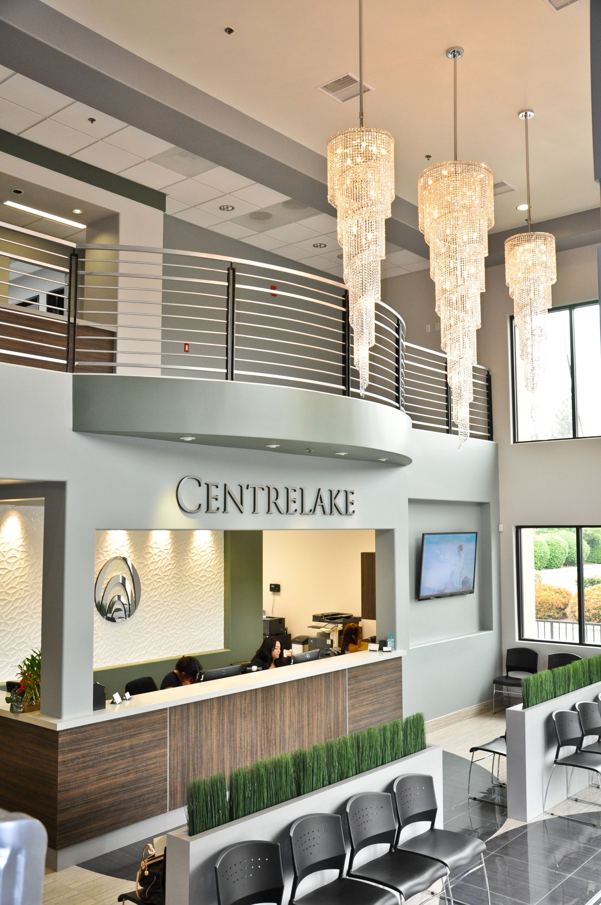 Reception area of CentreLake, with a front desk, waiting area, and chandeliers.