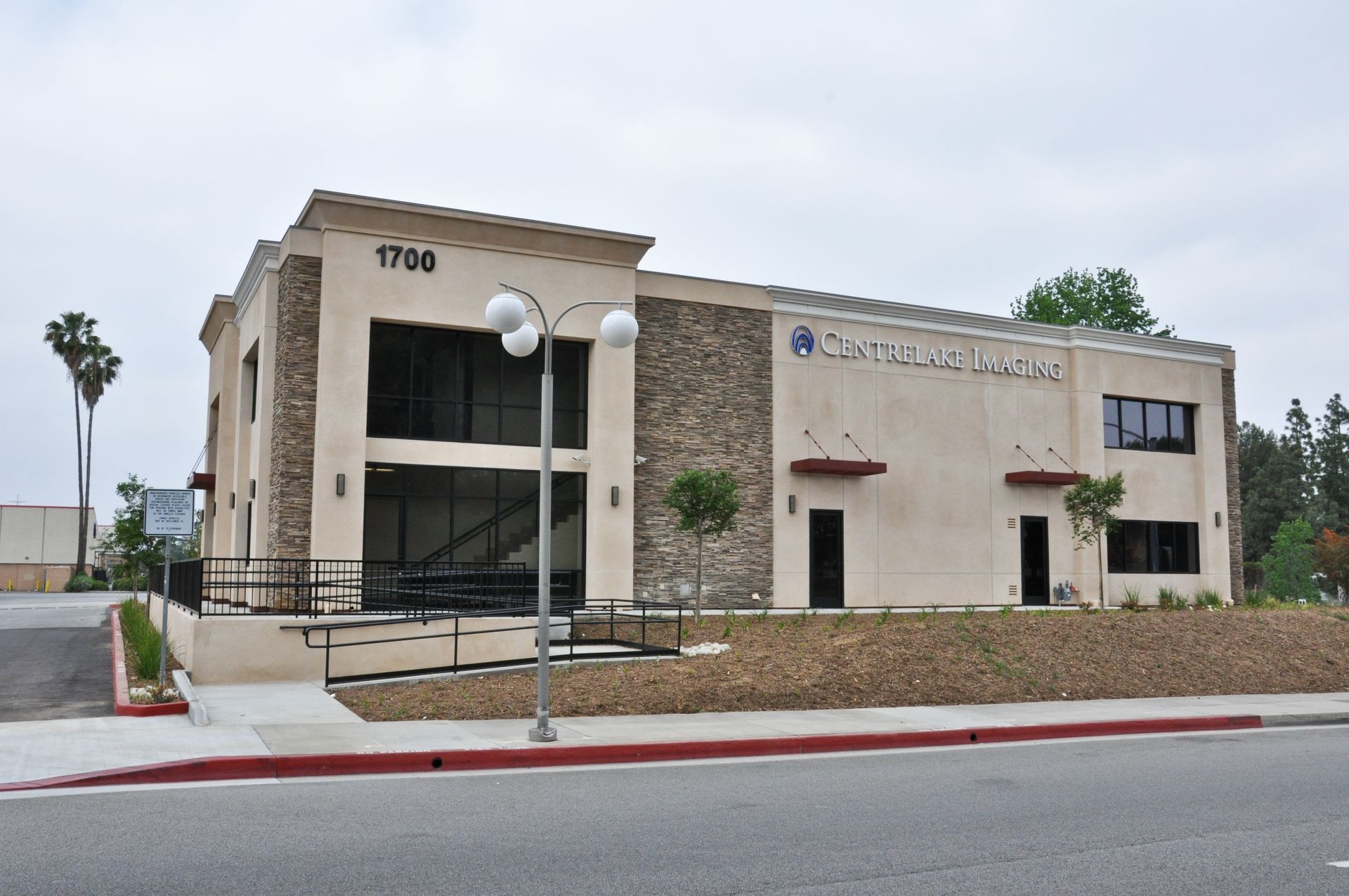 Commercial building with stone accents, address 1780, next to a sidewalk and street.