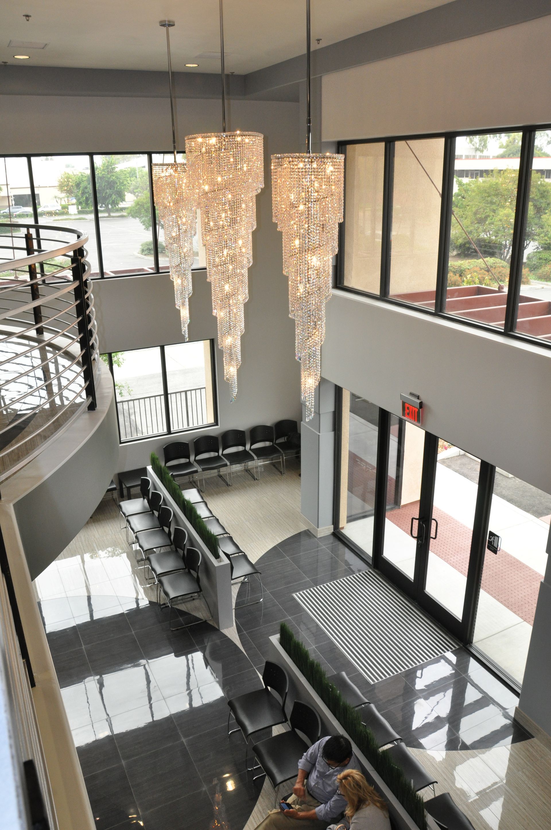 High-angle shot of an office lobby with chandeliers, windows, and seating area.
