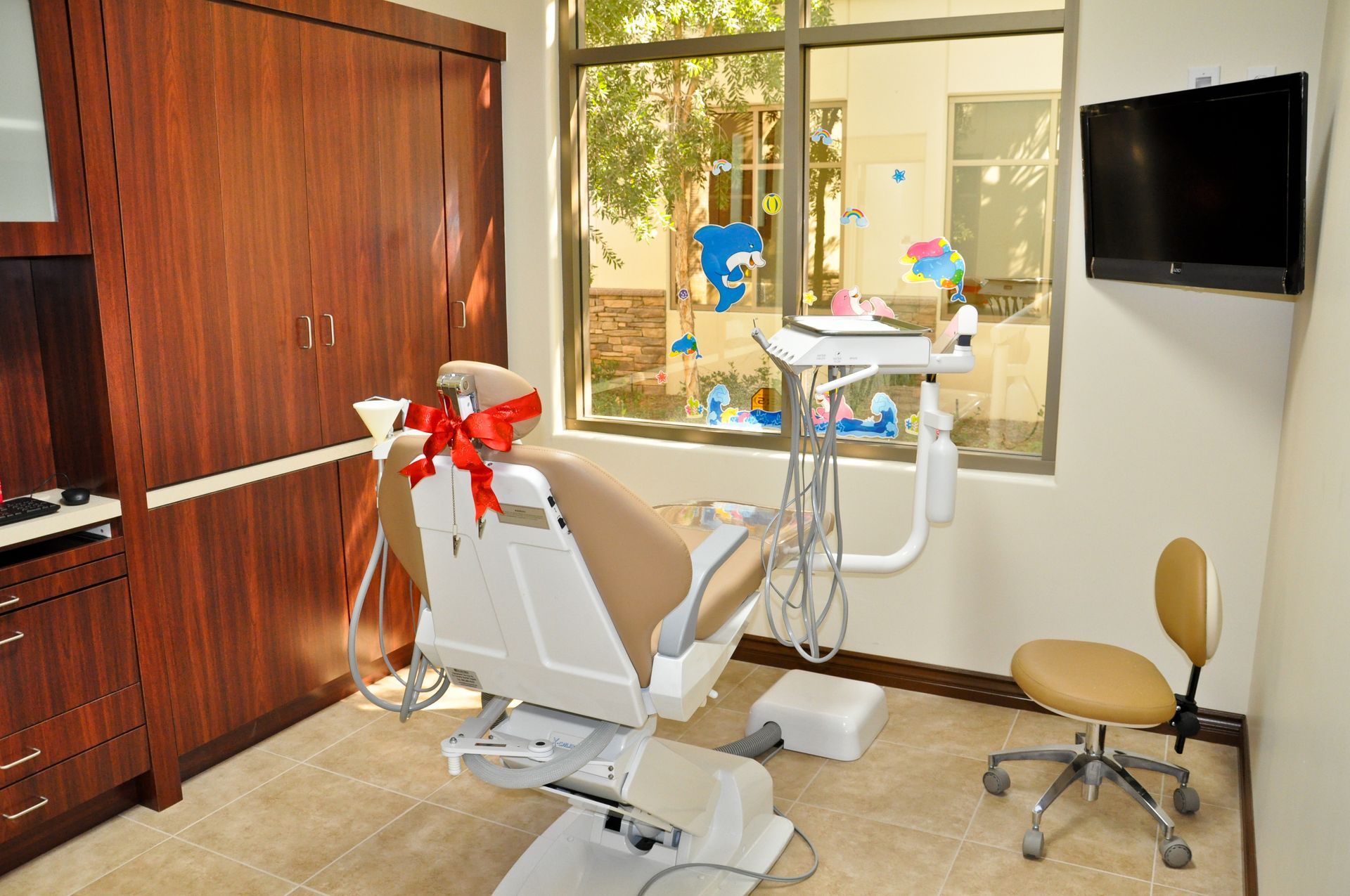 Dental examination room with a chair, equipment, and window.