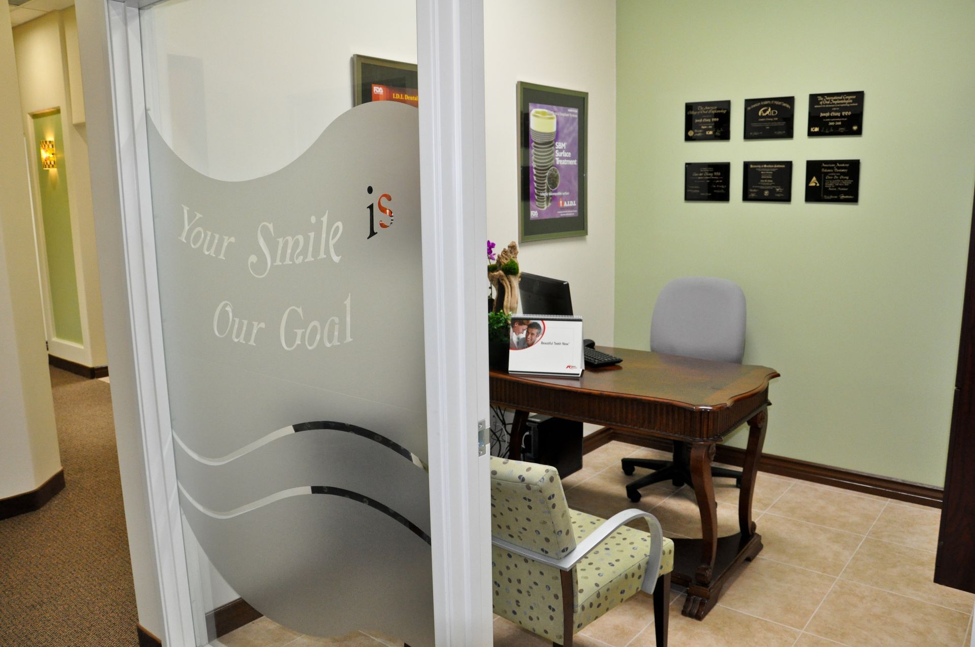 Office with desk, chair, green walls, frosted door, and decor. 
