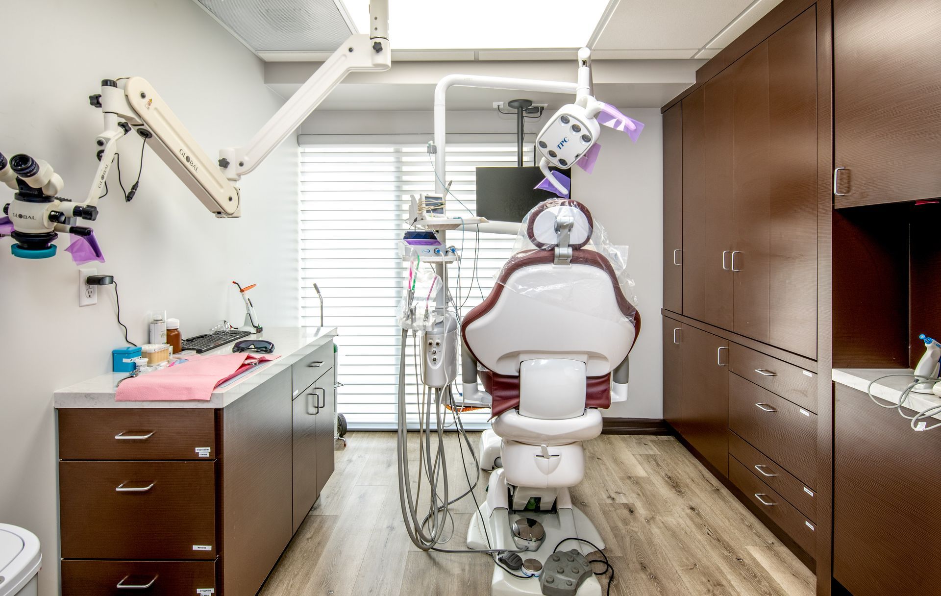 Dental office with a patient chair, cabinets, and equipment.