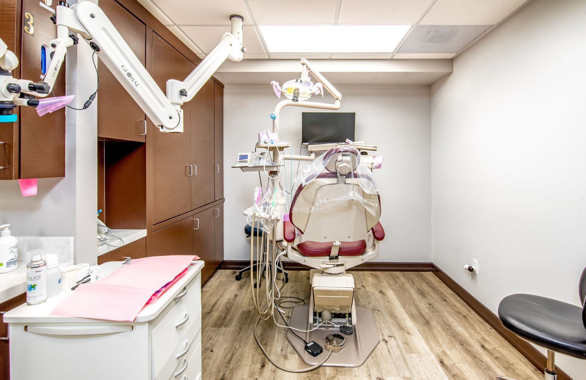 Dental office with dental chair, equipment, and cabinetry.