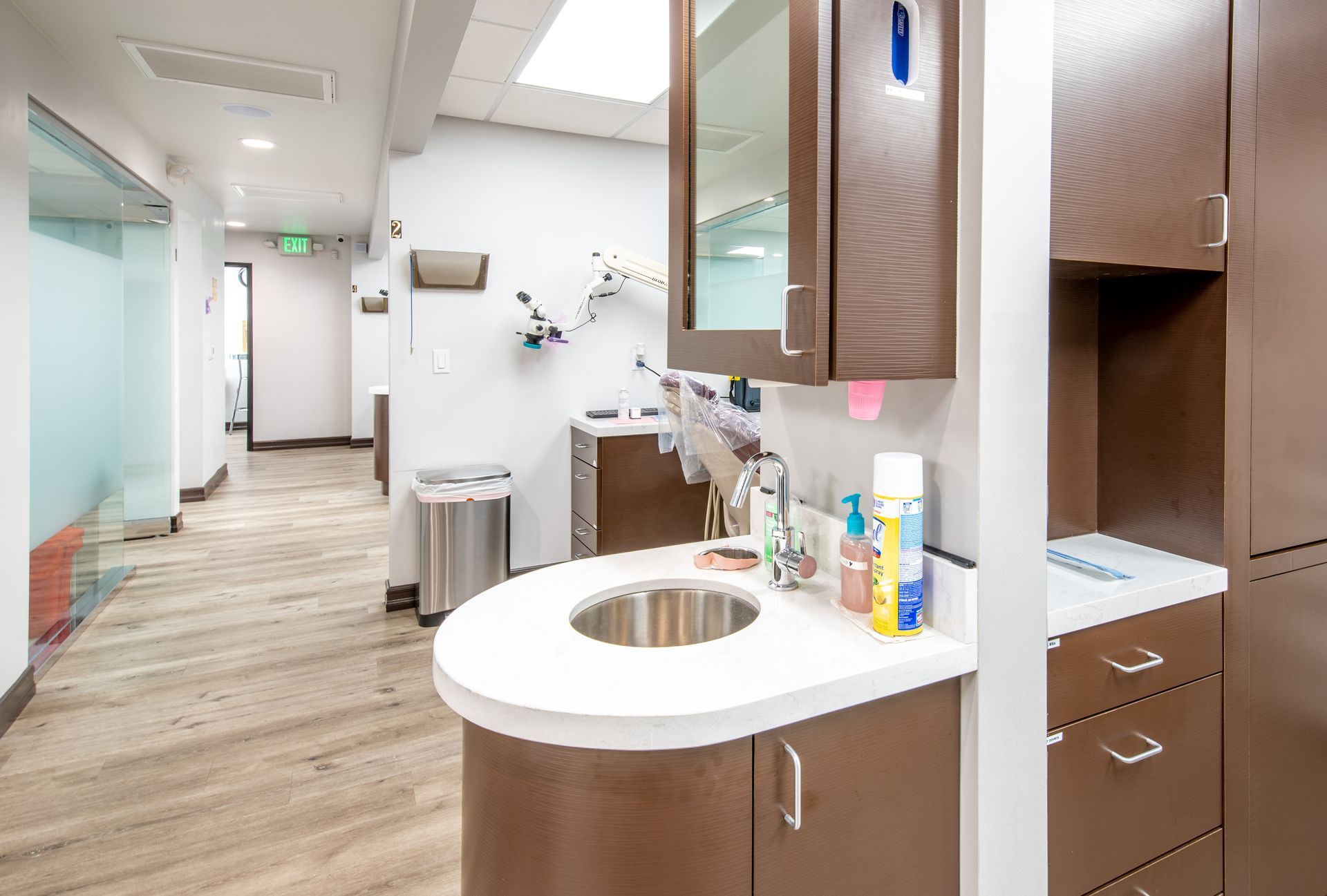 Hallway in dental office with sink, cabinets, and exam rooms.
