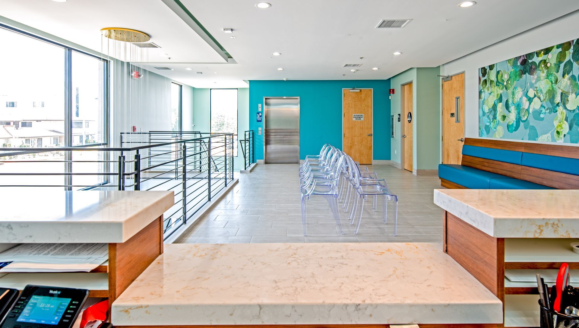 Reception area in a medical office with a desk, waiting chairs, and colorful walls.