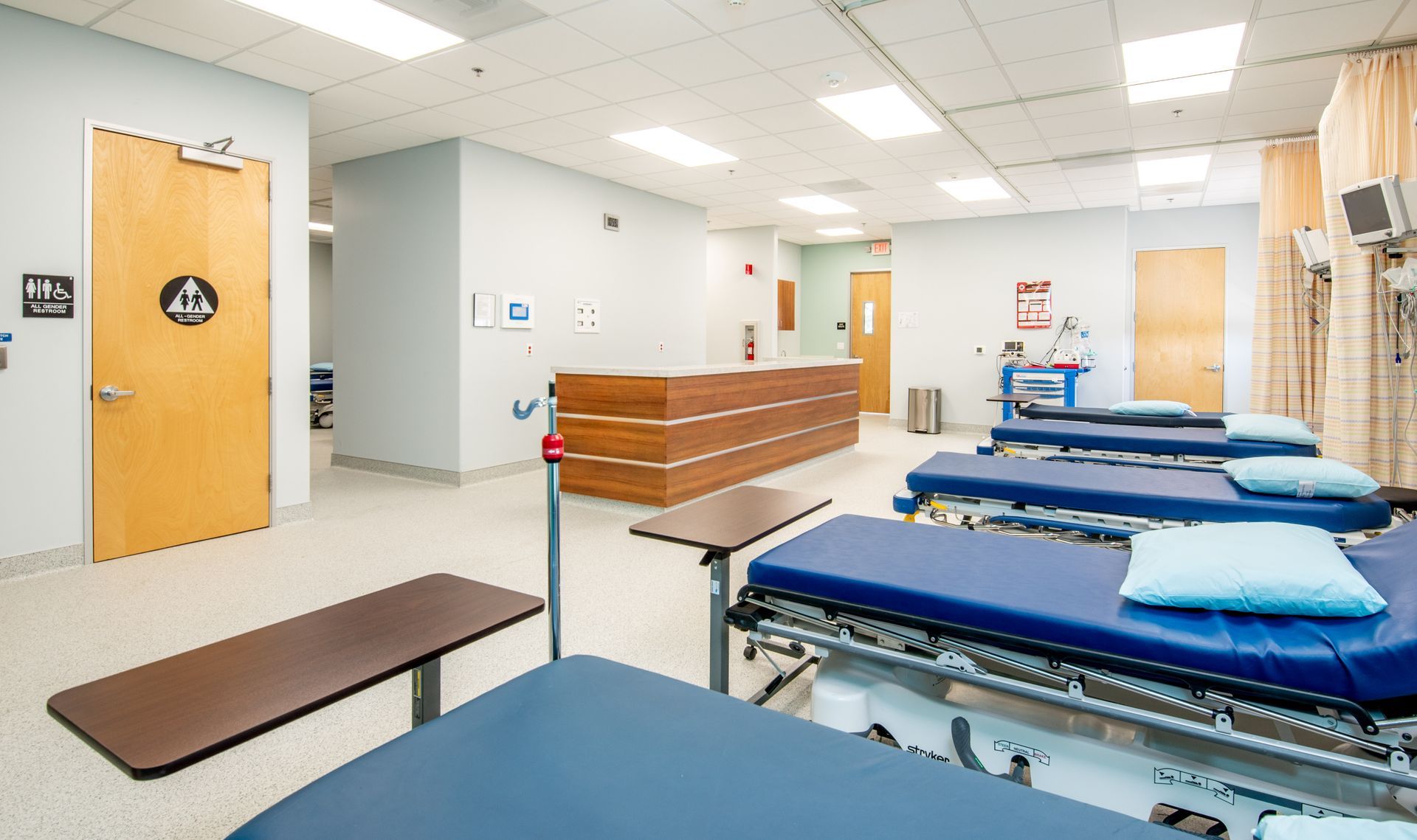 Emergency room with beds, a reception desk, and equipment.