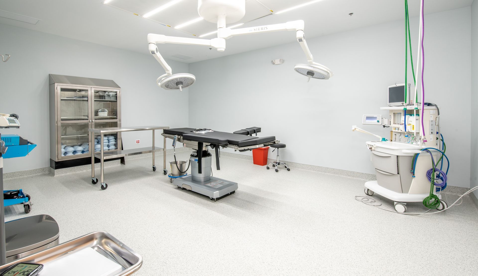 Operating room with surgical table, medical equipment, and overhead lights.