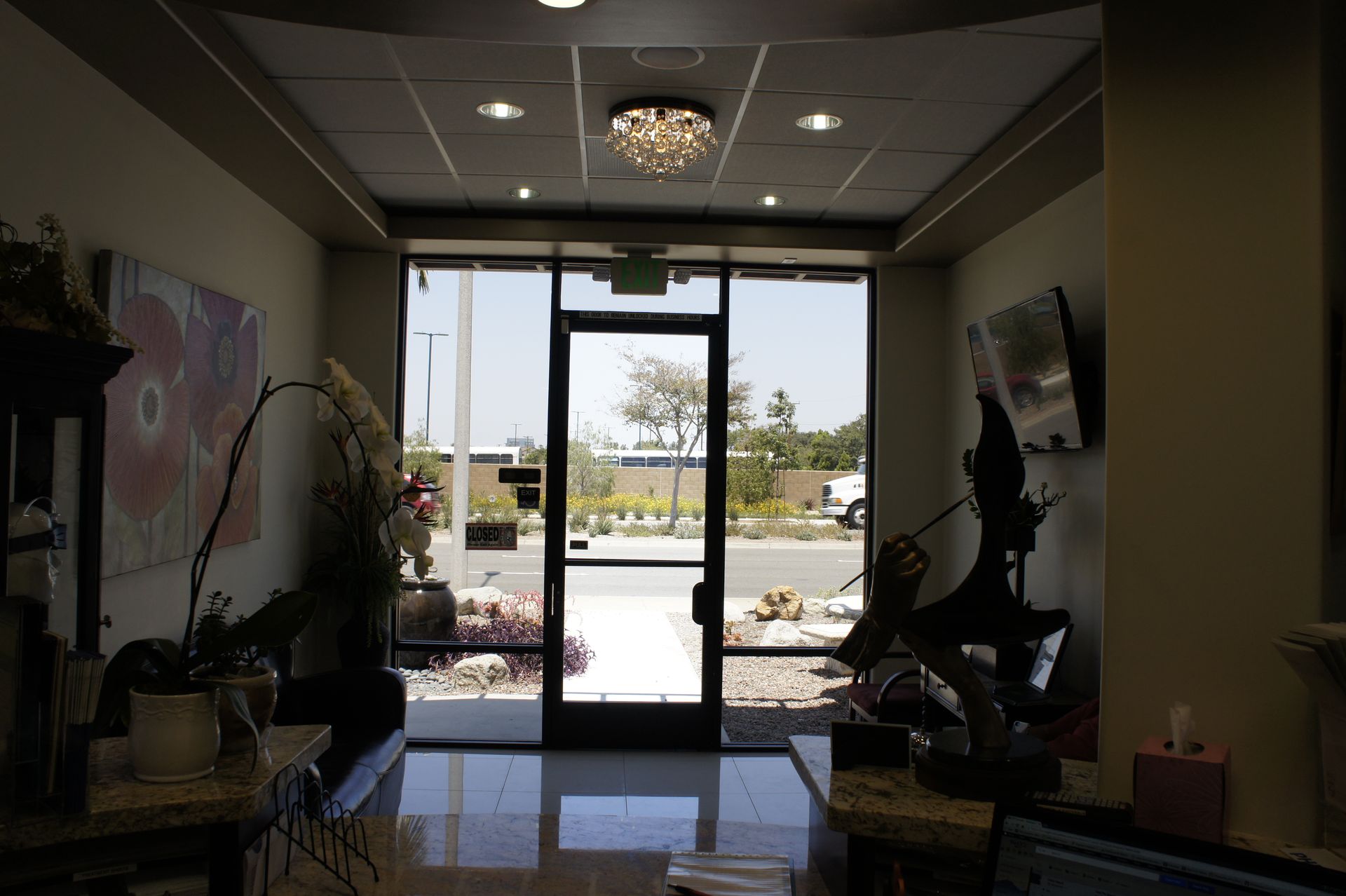 Interior of a well-lit entry with glass doors leading outside; decorations line walls.