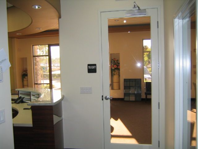 Interior view of an office, with a reception area and doorway to a waiting room.
