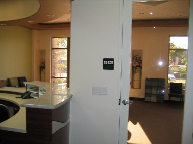 Reception area of a business. White walls, granite countertop, door leading to another room.