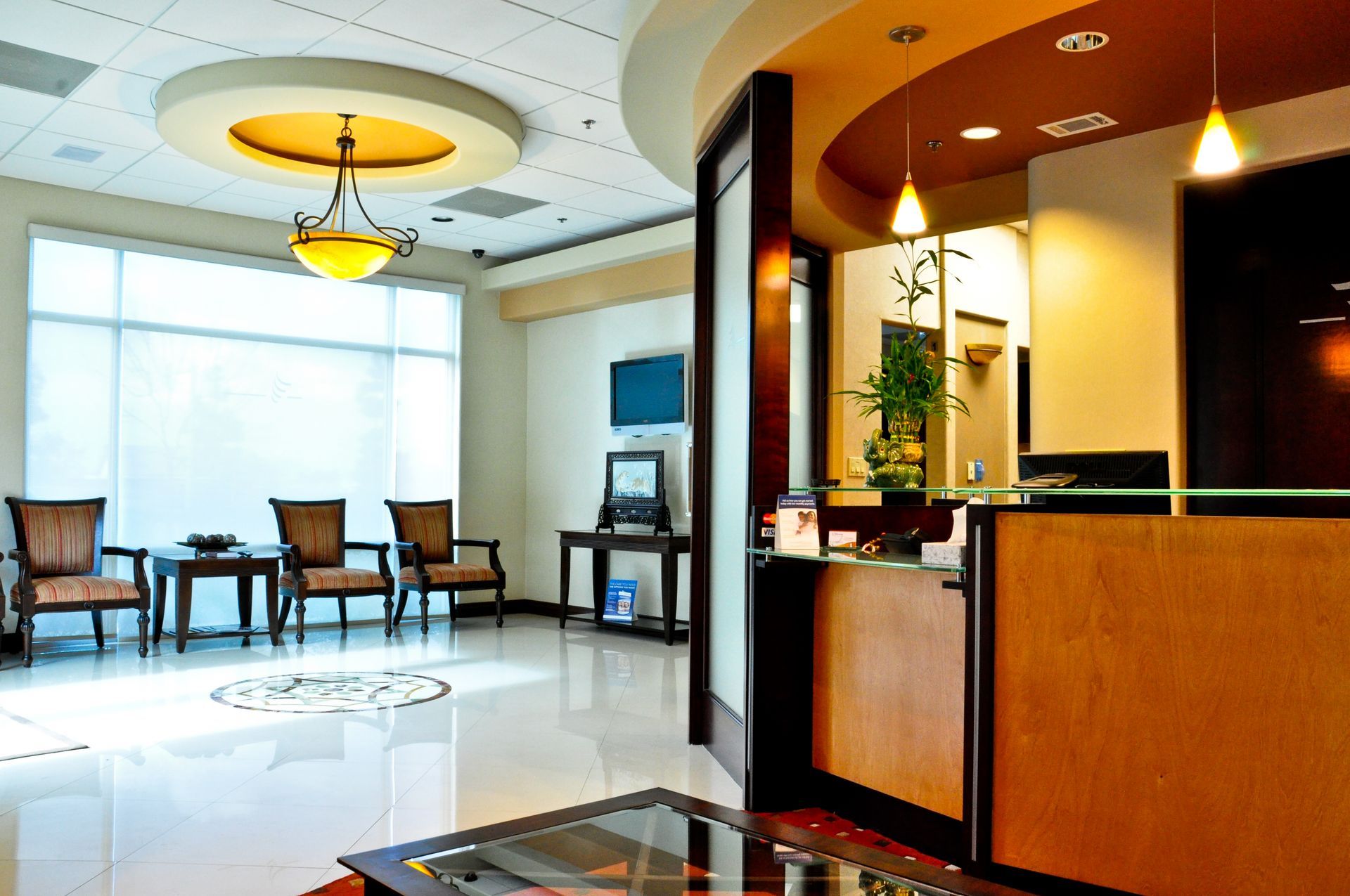 Reception area with chairs, reception desk, and a decorative ceiling fixture.
