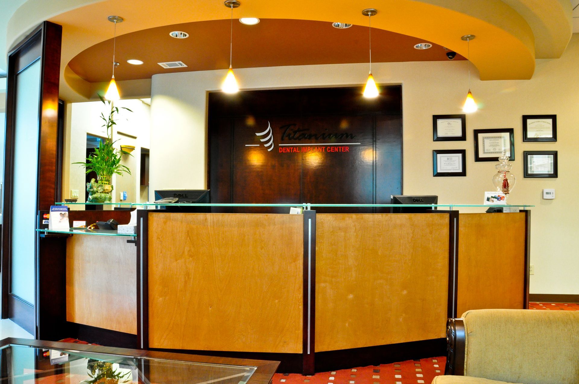 Reception desk in a professional office; wooden panels, brown and gold color scheme.