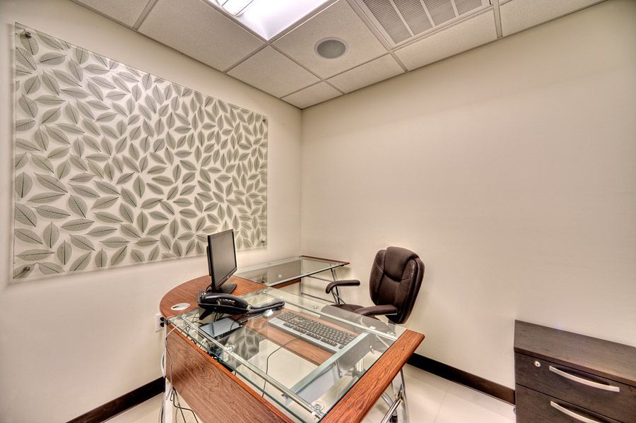 Small office with desk, chair, and decorative wall covering.