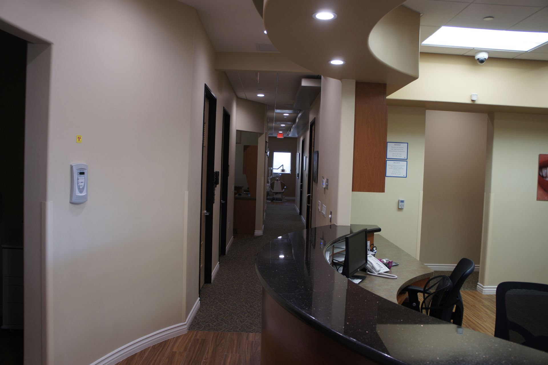 Dental office hallway with a black countertop and several closed doors.