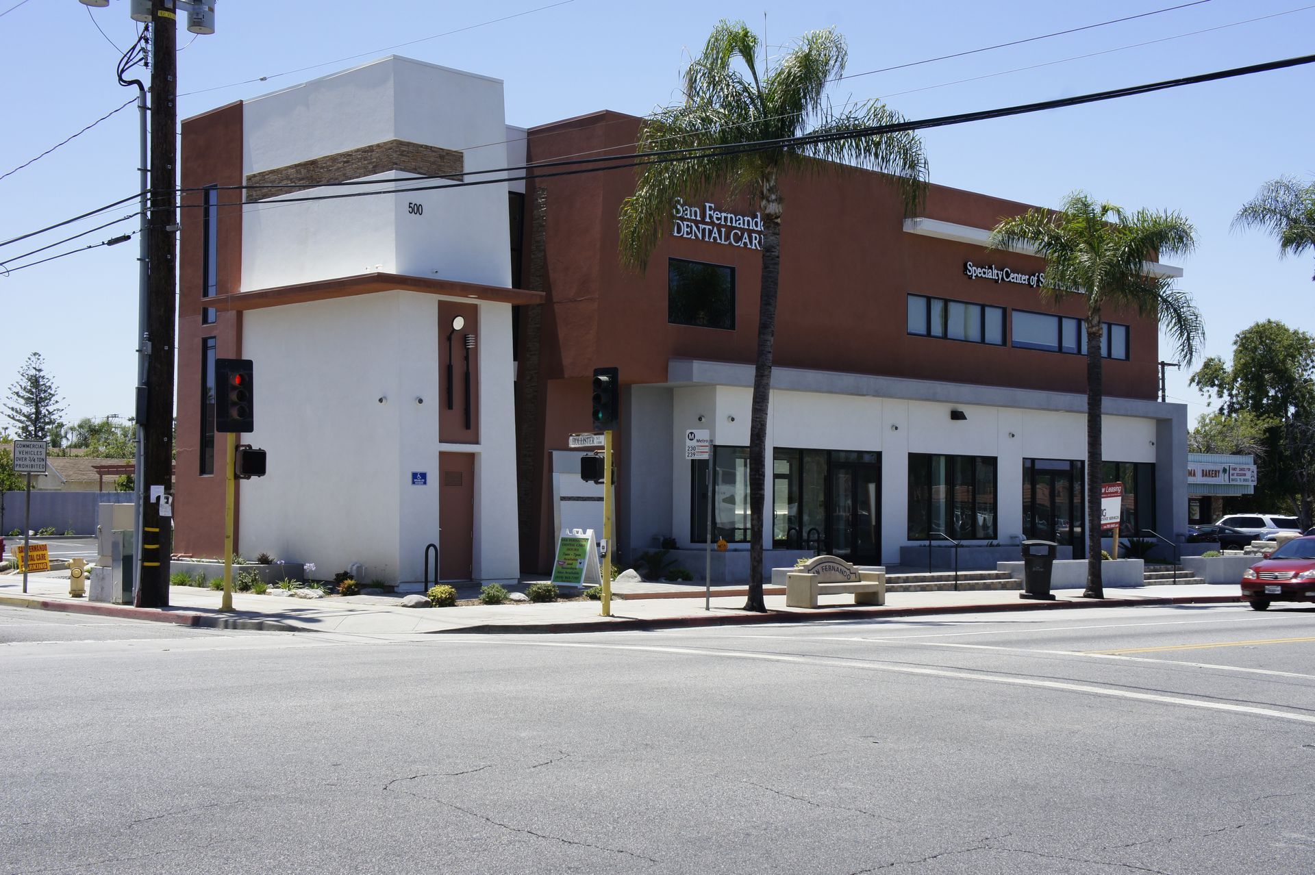 medical building with brick facade, palm trees, and street intersection.