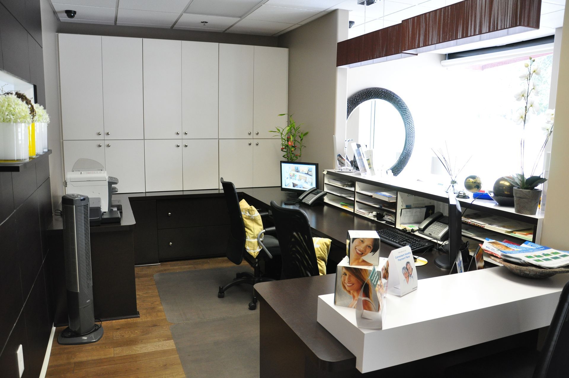 Reception area with desk, cabinets, window, and display.
