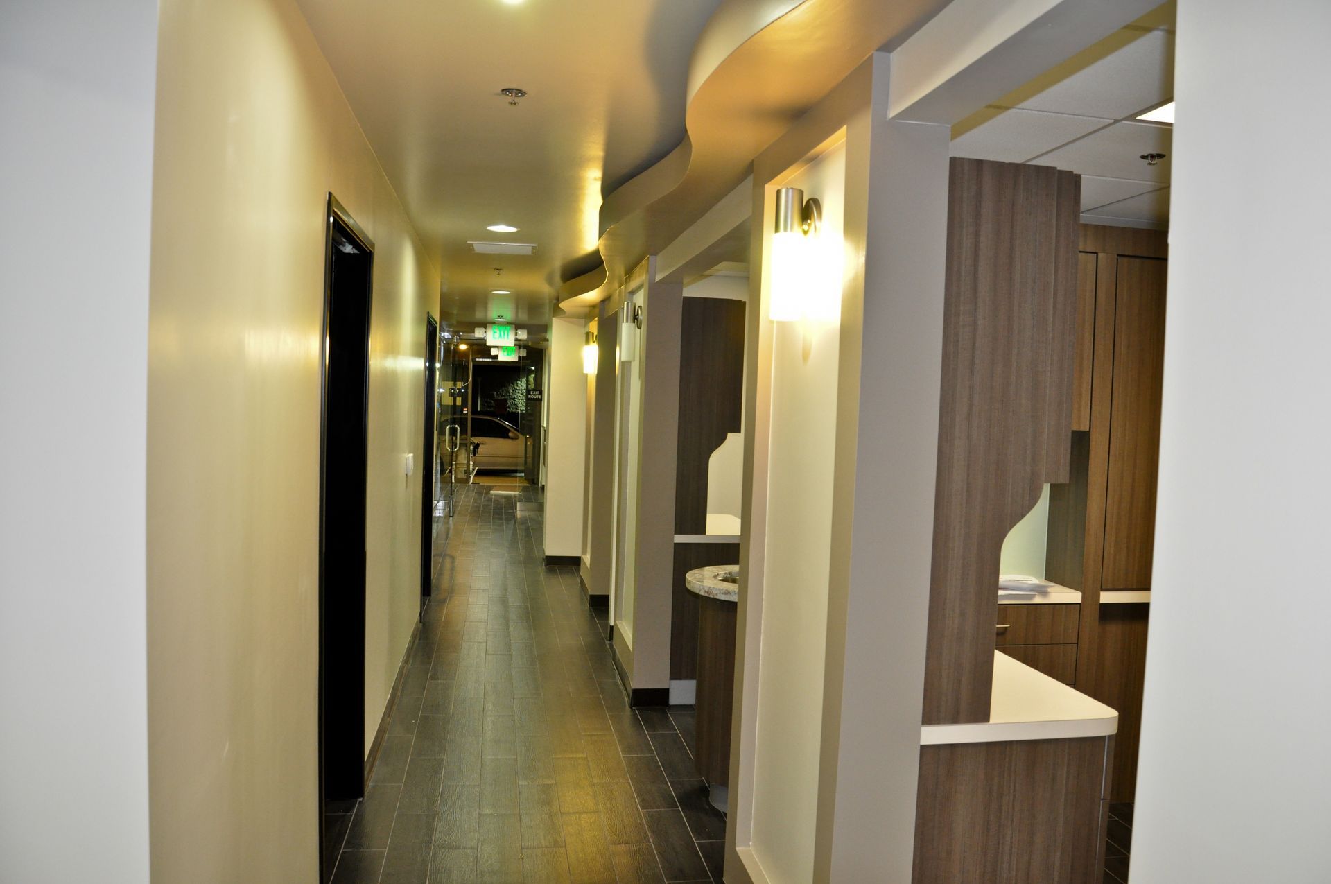 Long, narrow, well-lit hallway with dental office stations along the right side.
