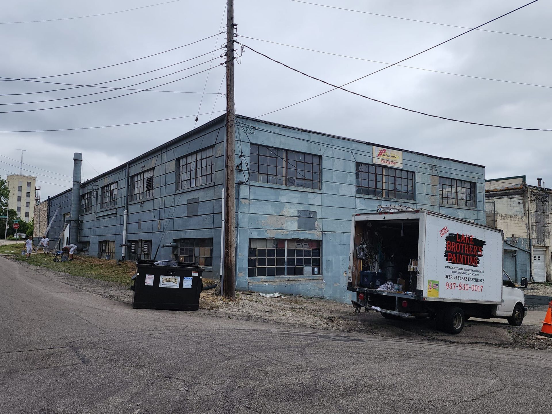 A white truck is parked in front of a blue building.