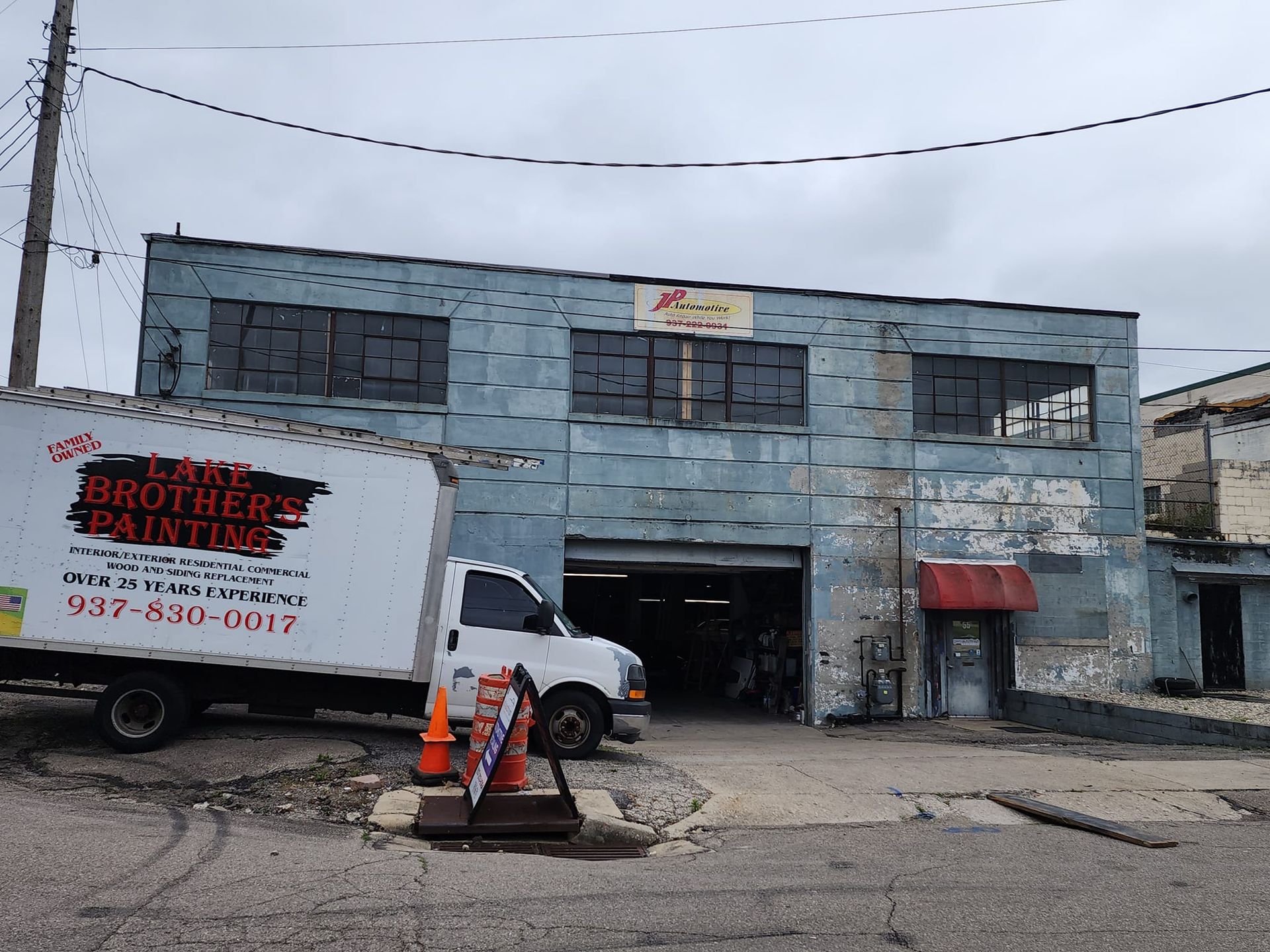 A white truck is parked in front of a building that says lake brothers painting
