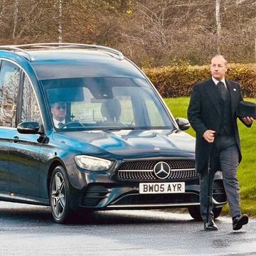 Barry  Whalen walking in front of the funeral car