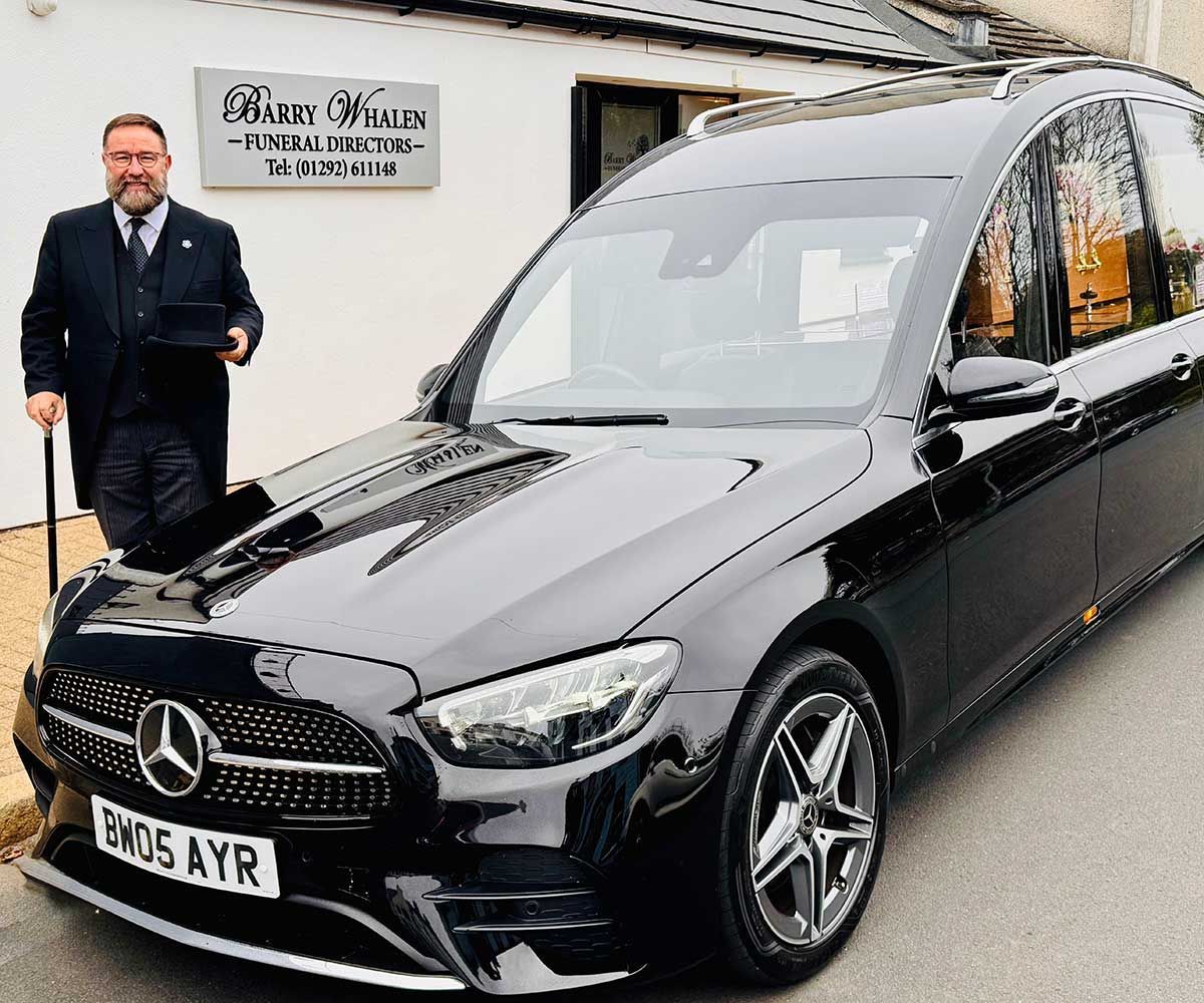 Barry Whalen walking in front of the cars