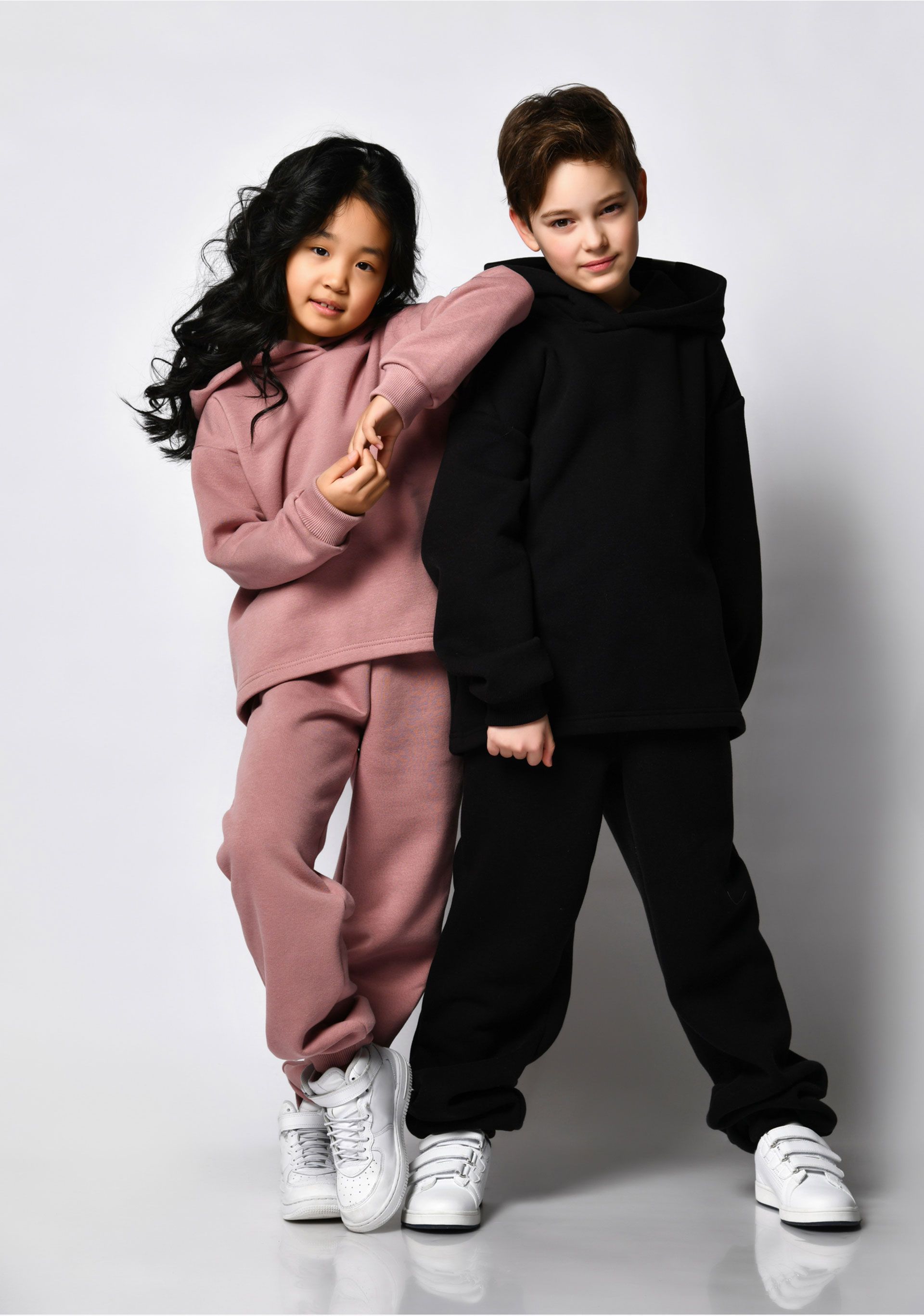 A boy and a girl are posing for a picture together.