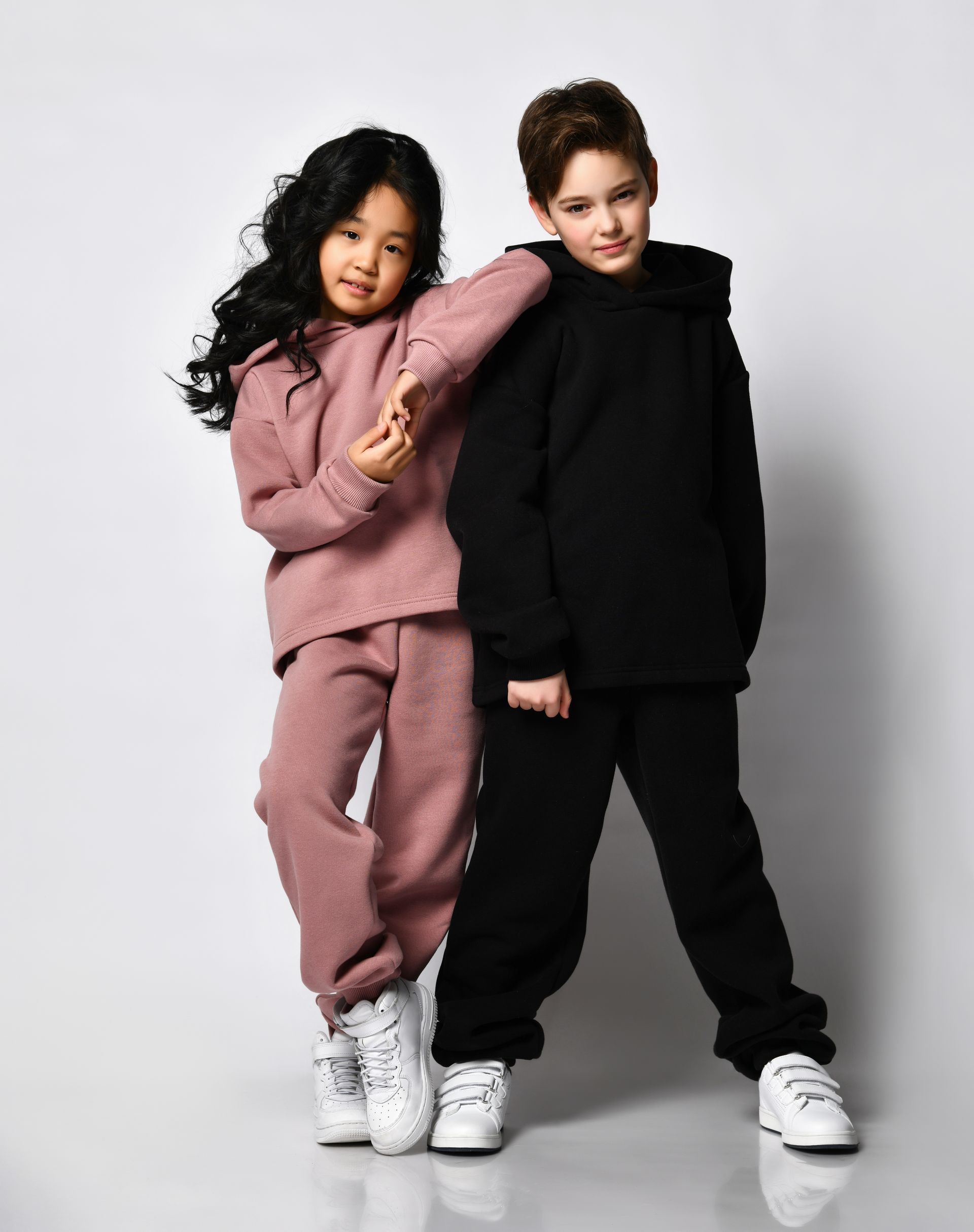 A boy and a girl are posing for a picture together.