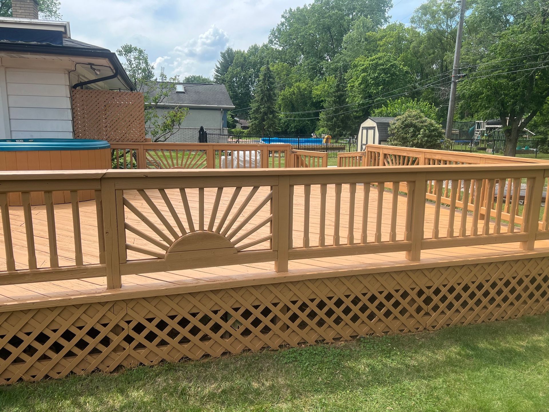 A wooden deck with a sun design on the railing