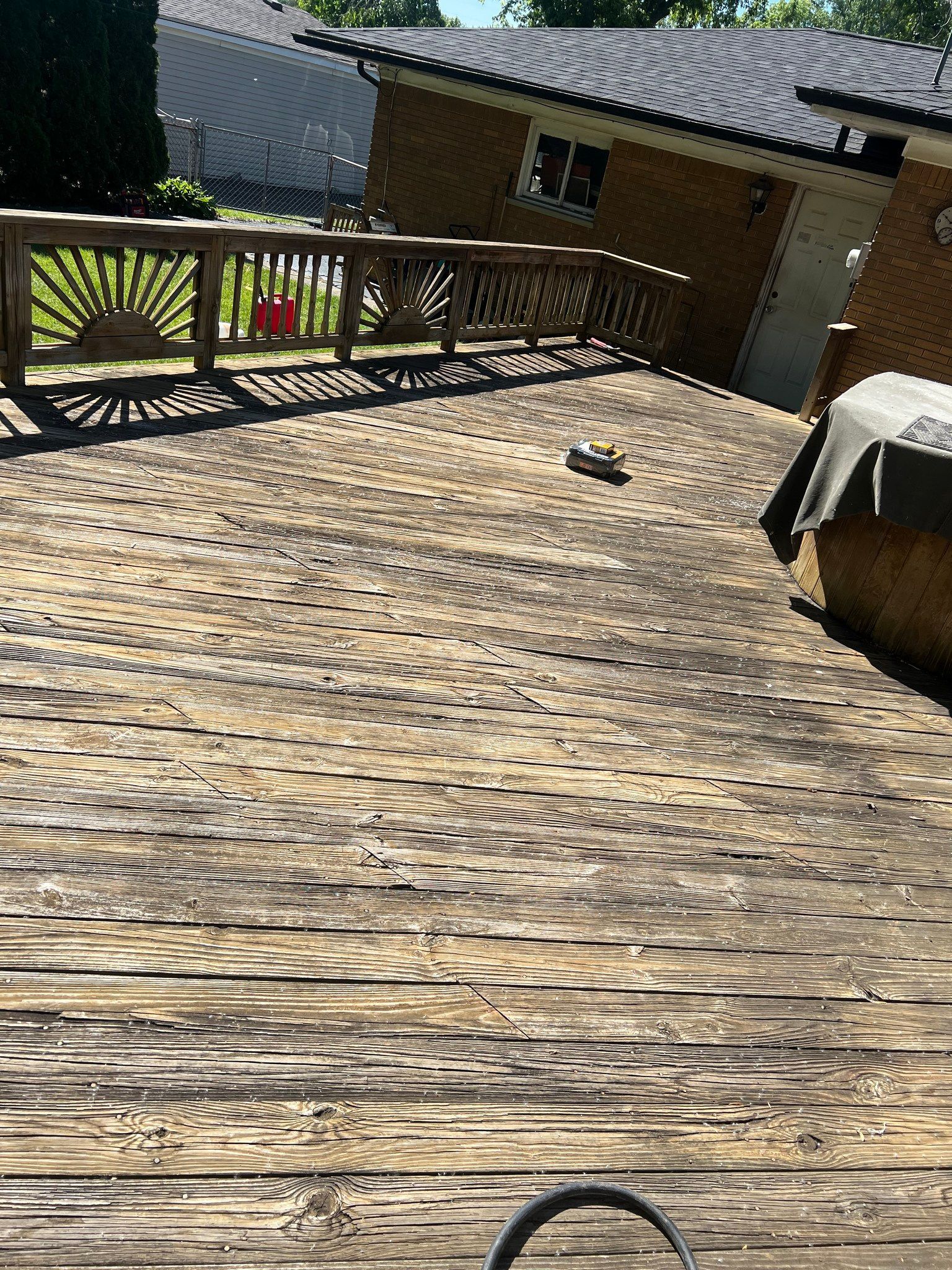 A wooden deck is sitting in front of a house.