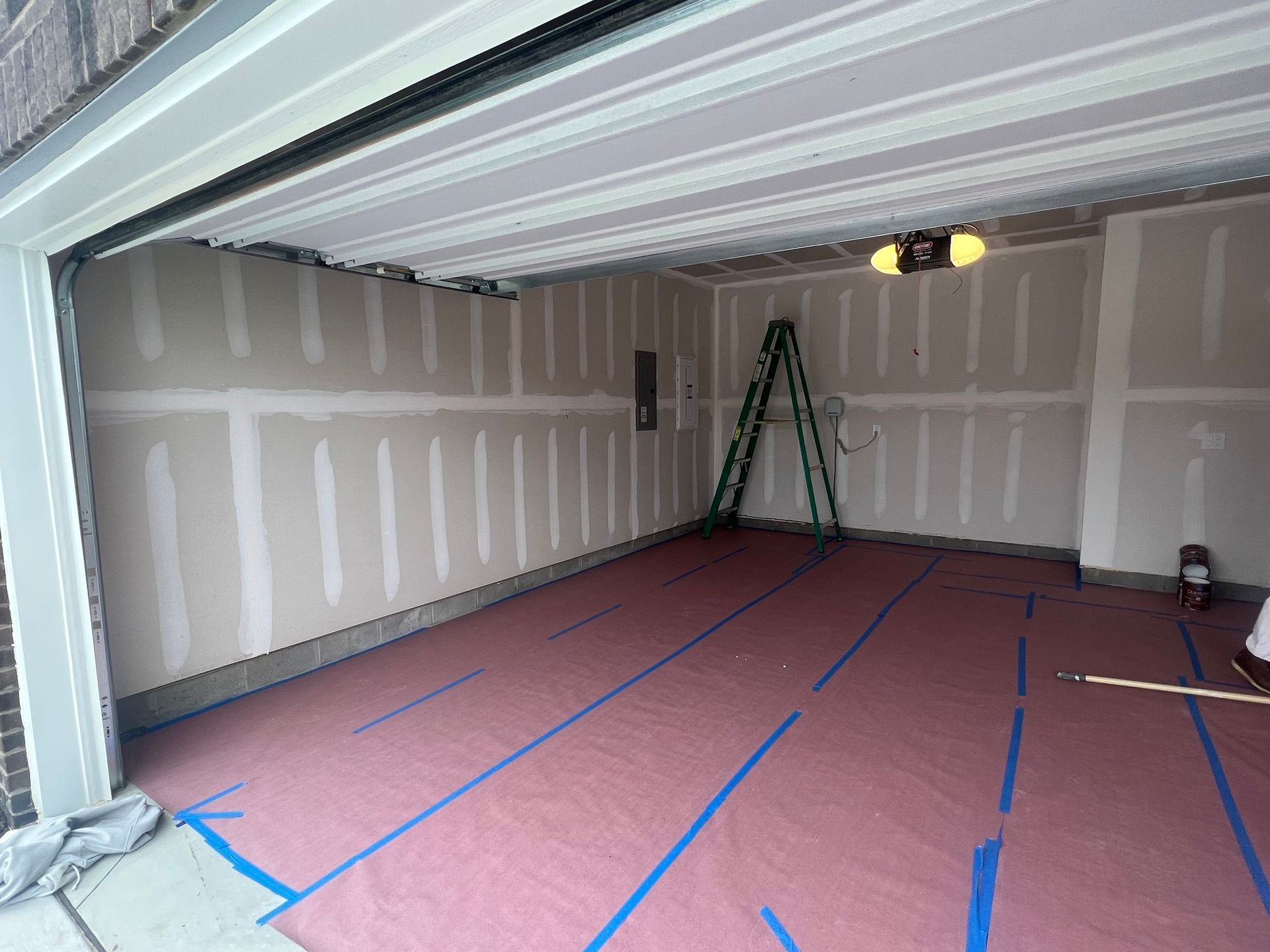 A garage with a ladder in it is being painted.