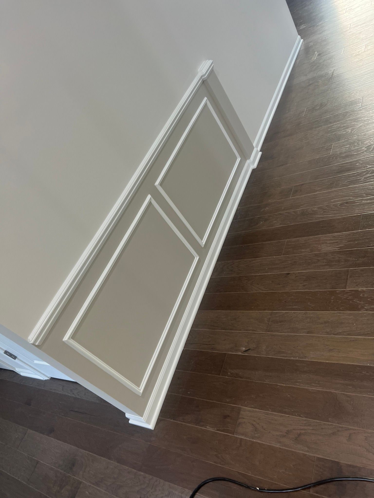 A room with a wooden floor and white trim on the wall.