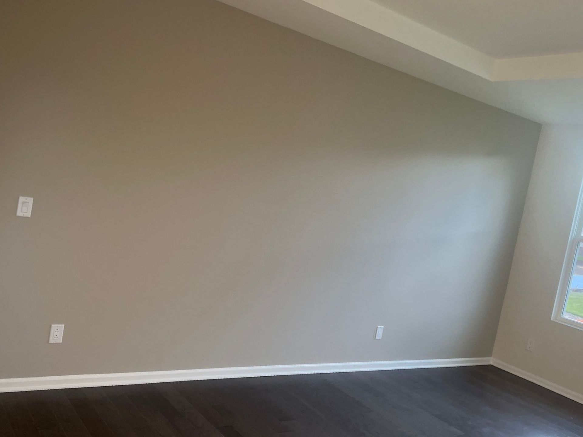 An empty room with a vaulted ceiling and a window.