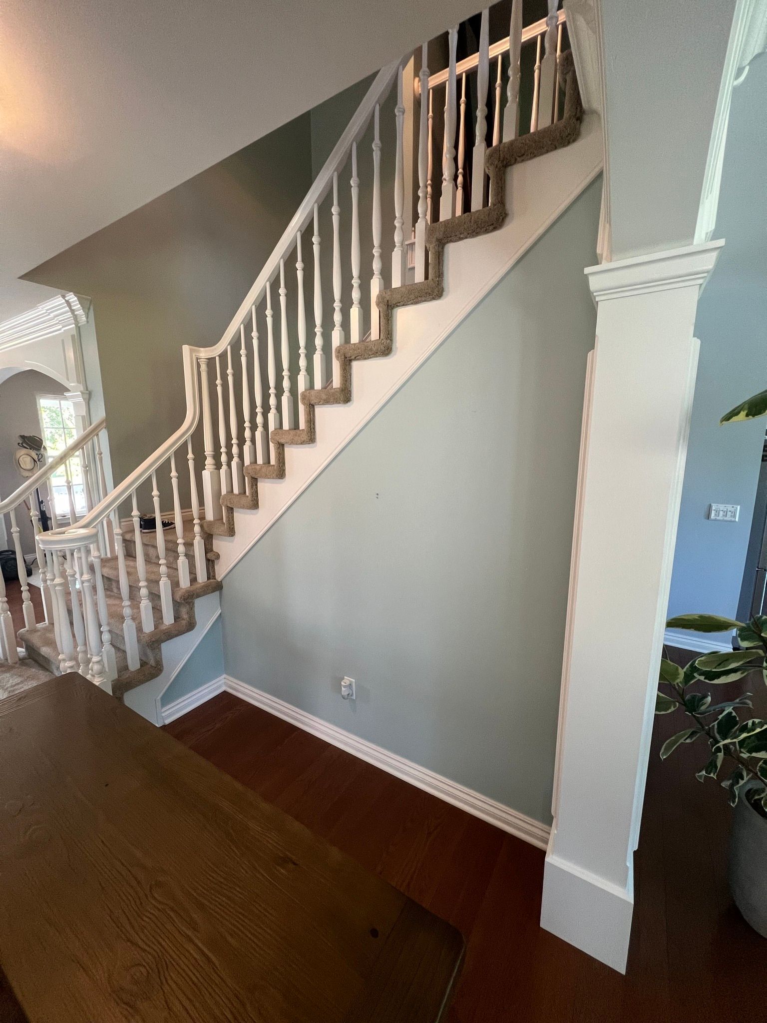 A staircase in a house with a wooden railing and a wooden floor.