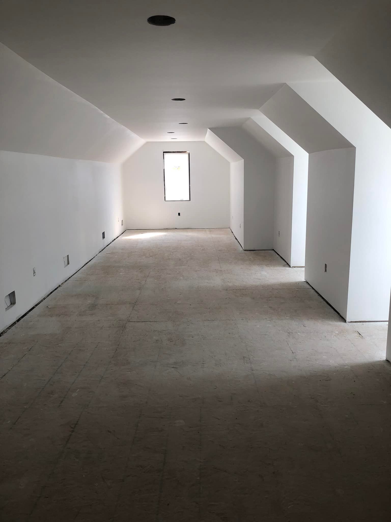 An empty room with white walls and a window