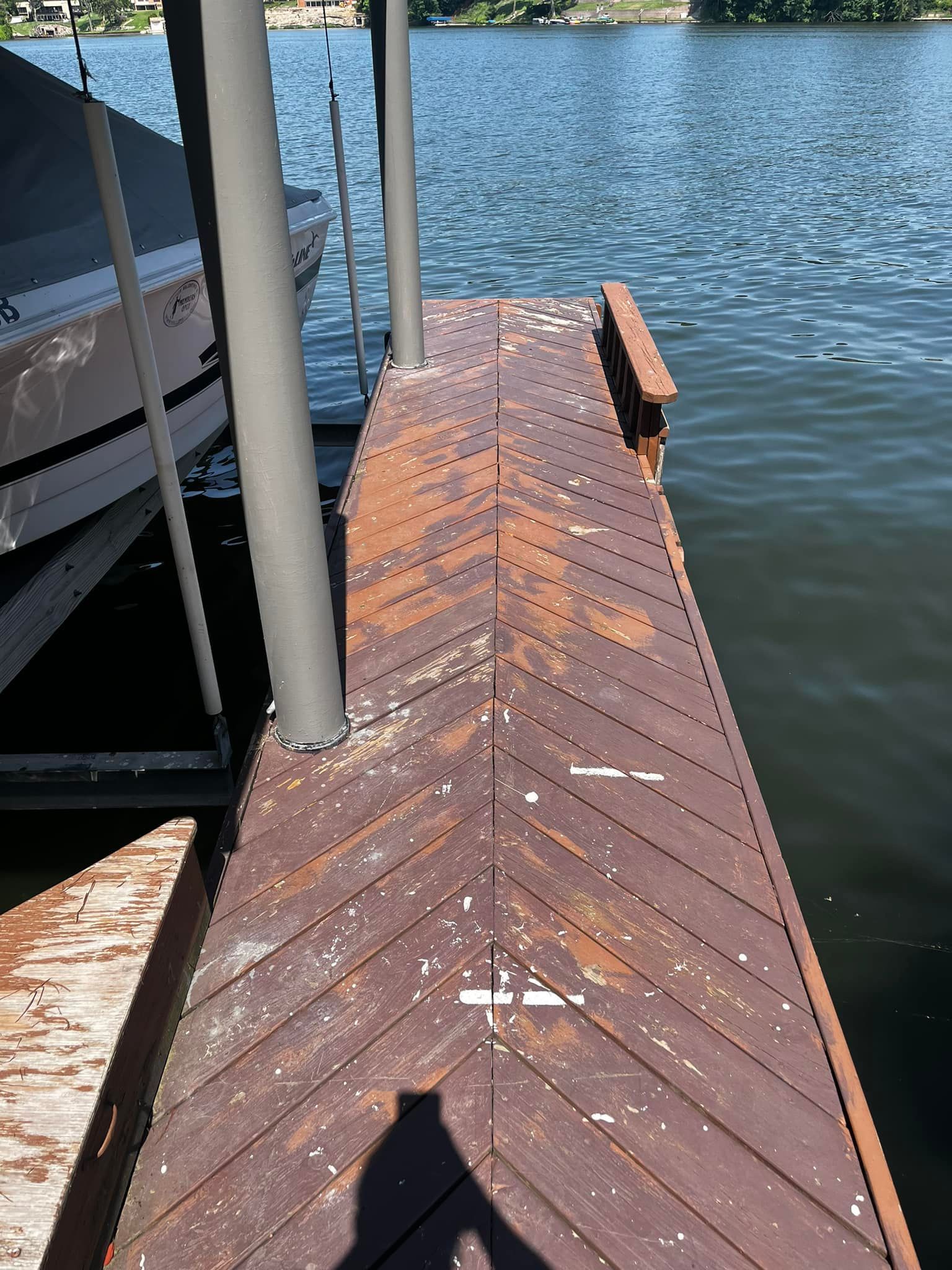 A boat is docked at a dock next to a body of water.