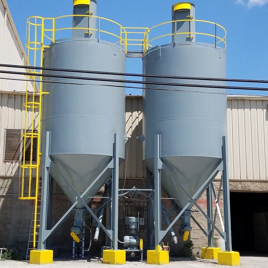 A couple of silos with a yellow railing on top of them