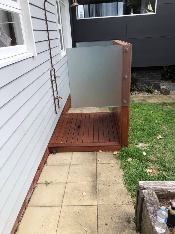 A Wooden Walkway Leading to A Shower Outside of A House — Gads Glass & Shower Screens in Albion Park, NSW