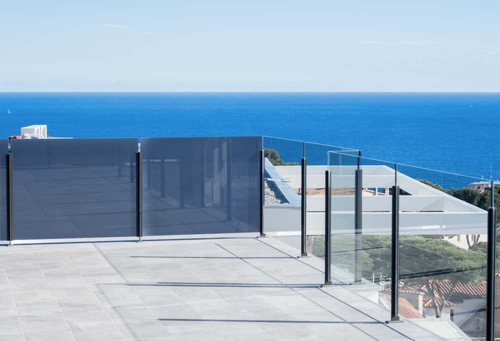 A Balcony with A Glass Railing Overlooking the Ocean — Gads Glass & Shower Screens in Woonona, NSW