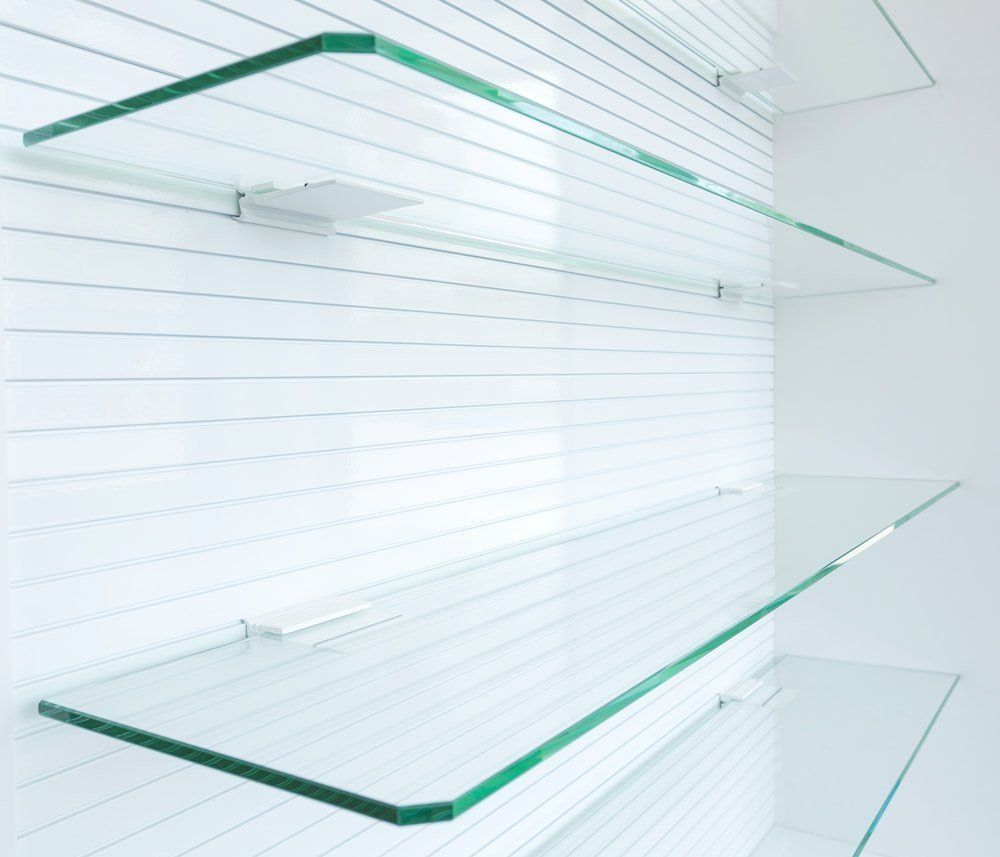 Three Empty Glass Shelves Against a White Wall — Gads Glass & Shower Screens in Albion Park, NSW