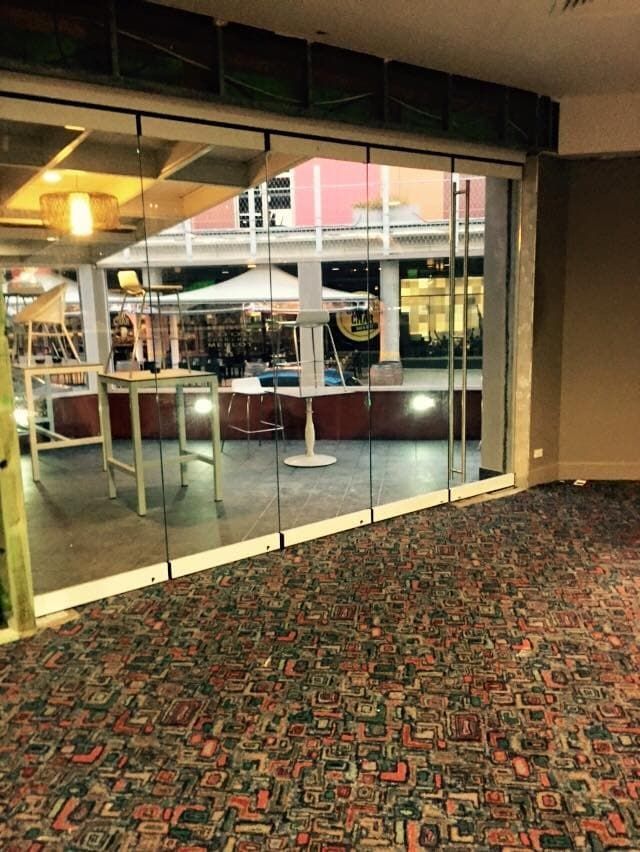 An Empty Room with A Carpeted Floor and A Glass Door — Gads Glass & Shower Screens in Albion Park, NSW