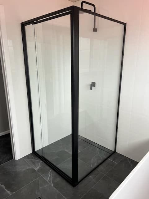 A Shower Stall with A Black Frame and Clear Glass in A Bathroom — Gads Glass & Shower Screens in Woonona, NSW